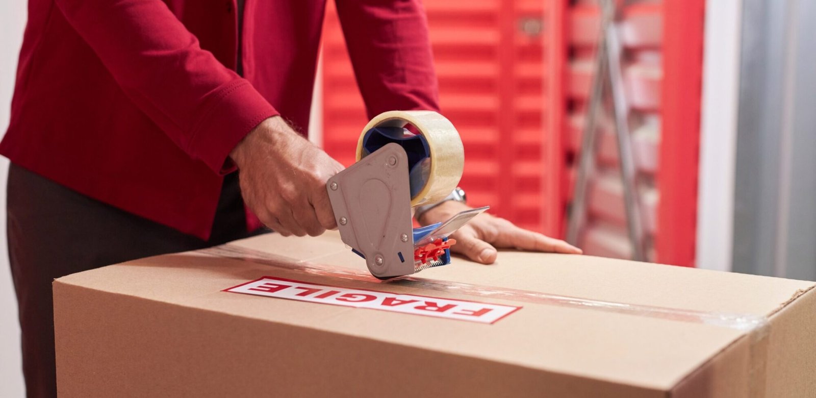man taping moving boxes in warehouse 5glahzf