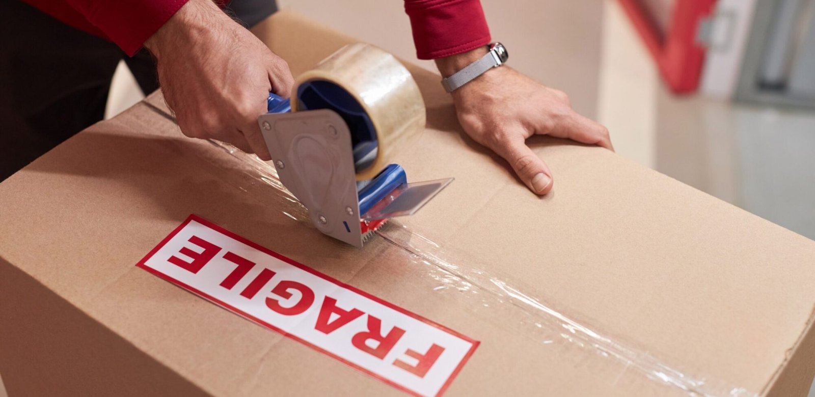 storage worker taping boxes in warehouse f6ajljv